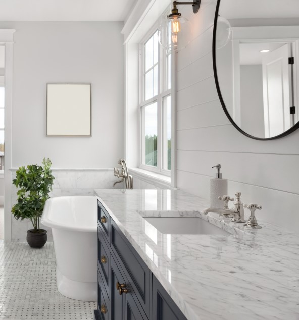 luxurious bathroom with dark grey vanity and white tub